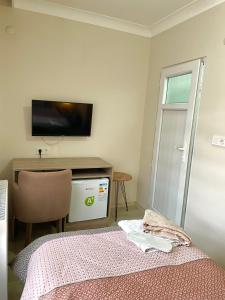 a bedroom with a bed and a desk with a tv at TEKİNLER OTEL in Balıkesir