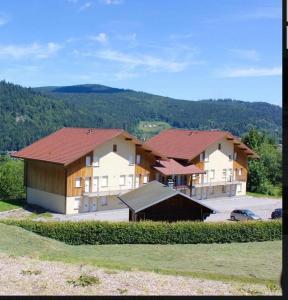 un groupe de maisons avec une voiture garée devant dans l'établissement APPT 3* LE HAUT DES LACS, à Xonrupt-Longemer