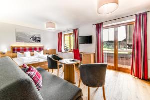 a living room with a couch and chairs at Hotel Steinbock in Mittelberg