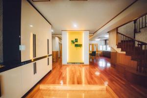 un pasillo vacío con una puerta amarilla y escaleras en クリスタルヴィラ金城 en Naha