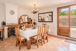 Un comedor con una mesa y sillas y un espejo. en Ca la Pradina, en Pollensa