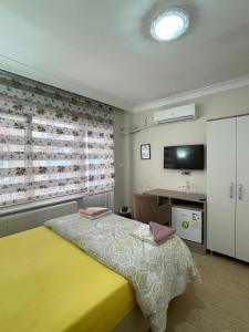 sypialnia z żółtym łóżkiem i oknem w obiekcie TEKİNLER OTEL w mieście Balıkesir
