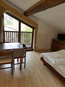 1 Schlafzimmer mit 2 Betten, einem Tisch und Stühlen in der Unterkunft Villa Paola in Lavarone