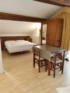 1 dormitorio con 1 cama, mesa y sillas en Villa Paola, en Lavarone