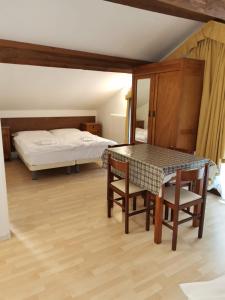 a bedroom with a bed and a table and chairs at Villa Paola in Lavarone