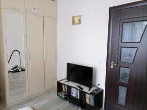 a living room with a tv and a door at White home-apartament in Burgas City