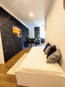 uma cama grande num quarto com uma parede de tijolos em Apartman Panorama Park & Free Parking em Žilina