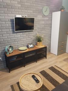 a living room with a tv on a brick wall at Apartament ul Okopowa - Parking płatny in Kołobrzeg