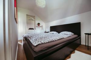 a bedroom with a large bed with a black headboard at Apartment Oddih in Bled