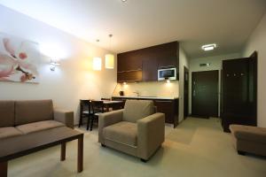 a living room with a couch and a dining room at Willa Port, apartament 204 in Ostróda
