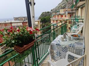 een balkon met een tafel en bloemen bij Ermes in Levanto