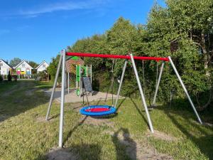 a swing set in a yard with a playground at Domki Letniskowe Malinka in Bobolin