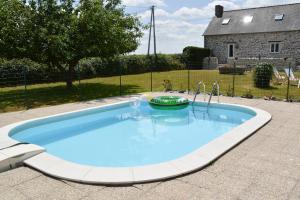 ein großer Pool in einem Hof mit einem Haus in der Unterkunft La Maison Neuve near Bagnoles de l'Orne in Madré