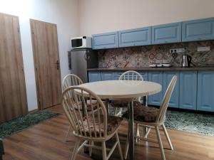 a kitchen with a table and chairs in a room at K-plus penzión in Štúrovo