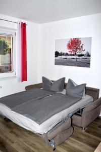 een bed in een kamer met een rode boom bij Ferienwohnung am Wasserturm in Zwenkau