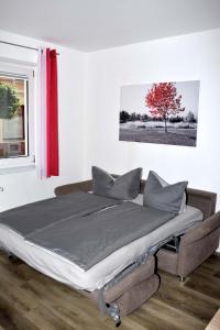 Cama en habitación con árbol rojo en Ferienwohnung am Wasserturm, en Zwenkau