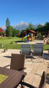 patio con mesa, sillas y parque infantil en Villa Gold en Nová Lesná