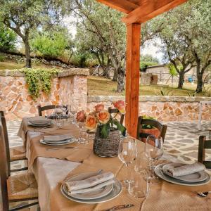 - une table pour un repas avec des fleurs et des verres à vin dans l'établissement Borgo Santa Lucia, à Cropani