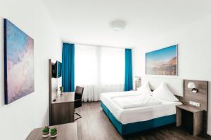 a hotel room with a bed, desk and a painting on the wall at Haus am Dom - Apartments und Ferienwohnungen in Cologne