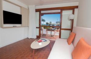 una sala de estar con un sofá y una mesa en Alsol Las Orquídeas, en Playa del Inglés
