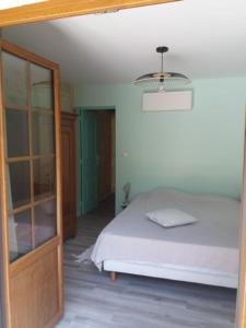 een slaapkamer met een bed en een kroonluchter bij Gîte 6 personnes Les Gîtes du Chardon in Teuillac