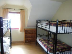 a bedroom with two bunk beds and a window at Brú na Dromoda/Dromid Hostel in Killeenleagh Bridge