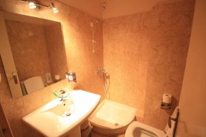 a bathroom with a sink and a toilet and a mirror at Ulrika in Egina