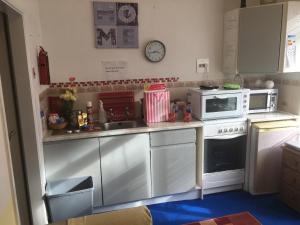 a small kitchen with a stove and a microwave at Beach Life in Dartmouth