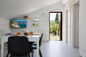 ein weißes Esszimmer mit einem weißen Tisch und Stühlen in der Unterkunft Appartamento Limone in Splendida villa Nature al mare di Scopello Zingaro in Scopello