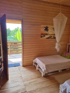 a room with a bed and a sliding glass door at Jo's Nature Cabin in SantʼAna