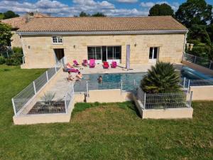 una casa con una piscina con gente en el patio en Gîte 6 personnes Les Gîtes du Chardon en Teuillac