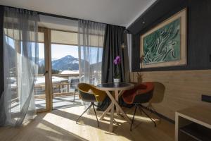 a dining room with a table and chairs and a window at Locanda degli Artisti Art Hotel in Canazei