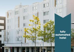 a white building with a blue sign in front of it at Hotel Ecu in Genk