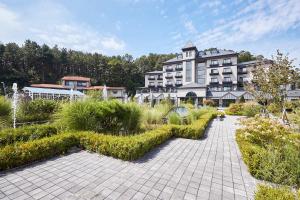 un grand bâtiment avec un jardin en face dans l'établissement Eden Paradise Hotel, à Icheon