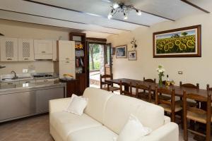 a living room with a white couch and a kitchen at Agriturismo Colle Pu in Assisi