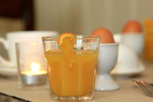 un vaso de zumo de naranja con una cáscara de naranja en él en B&B Laurus, en Ypres