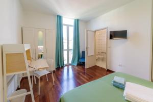 a room with a bed and a desk and a table at Dama Bed & Breakfast in Foligno