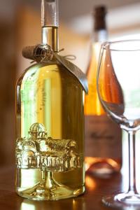 a bottle of oil sitting next to a wine glass at Andriana House in Šibenik