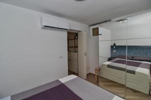 a bedroom with a bed and a glass wall at B&B Sea and Garden in Orbetello