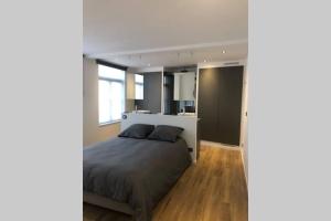 a bedroom with a bed and a large window at Les chambres Berguoises Duplex calme au coeur de Bergues in Bergues