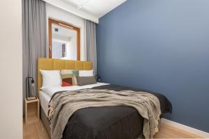um quarto com uma cama com uma parede azul em Rent like home - Karolkowa 28 II em Varsóvia