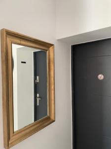 a mirror on a wall next to a door at Apartament w Sercu Gdańska in Gdańsk
