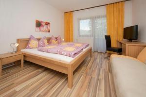 a bedroom with a bed and a tv in it at Appartement - Pension Adlerhorst in Velden am Wörthersee