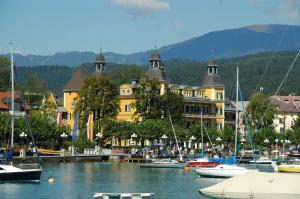 a group of boats in the water in front of a building at Appartement - Pension Adlerhorst in Velden am Wörthersee
