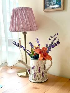 een vaas met bloemen naast een lamp bij Our House In The Town in Veliko Tŭrnovo