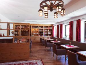 une salle à manger avec des tables et des chaises ainsi qu'un lustre dans l'établissement Hotel Tirolerhof, à Leutasch