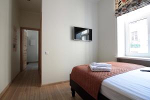 a bedroom with a bed and a television on the wall at Modern Cozy 1BR apartment in Quiet center of Riga in Rīga