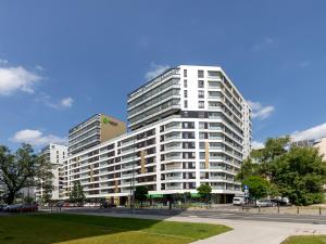 um edifício de apartamentos branco e alto numa cidade em Rent like home - Karolkowa 28 II em Varsóvia