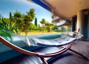 a hammock on a porch with a view of a pool at Apartments PERLA Budva in Budva