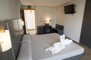 
a hotel room with a bed and a television at El Chalet in Cullera
